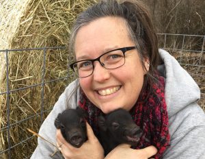 Shelly Trumpey holds Mulefoot piglets