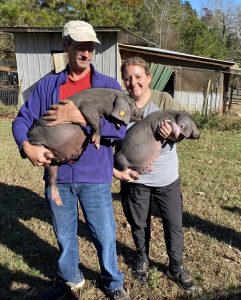 Bill and Laura Jensen hold Meishan piglets